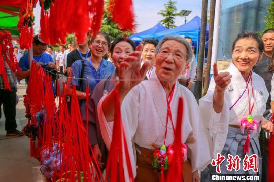 图为甘肃庆阳端午香包民俗文化节期间,日本友人参观游览。 陈飞 摄