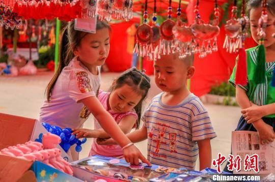 图为众多款式的香包吸引孩子们。 陈飞 摄