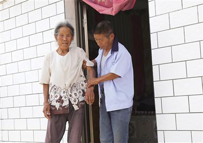 王雄(右)照顾毛靛兰老人 记者 金奉乾供图