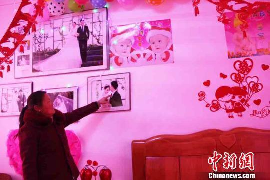 甘肃清水县后坡村村民李小燕特意穿了件喜庆的新衣服,为儿子史俊峰布置的新房就在小洋楼的二层,婚纱照悬挂在洁白的墙上。 徐雪 摄