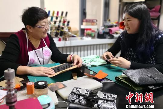 去年上半年,60岁的李丽和53岁的李霞姐妹俩在家人的提议下,开办手工皮具制作工作室,当起时尚创客,如今她们是生意越来越好。图为指导顾客做皮具。 刘玉桃 摄