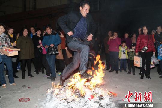 图为老年人跳过火堆。 郑兵 摄