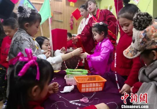 图为小朋友在老师指导下做手工。 刘玉桃 摄