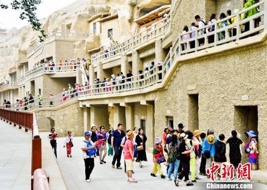 资料图:丝绸之路上的国际旅游名城甘肃敦煌迎来了传统旅游旺季,敦煌莫高窟游人如织。 王斌银 摄