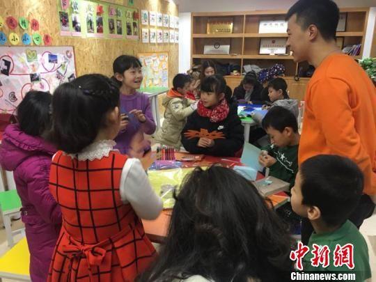 图为胡景蓉正在与老师交流自己制作面具的心得。 张婧