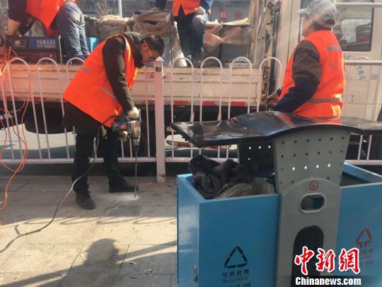 图为城关区环卫局设施维修队对城区主次干道的破旧果皮箱进行维修,并对施工提升改造路段缺额的果皮箱进行补充。 张婧 摄