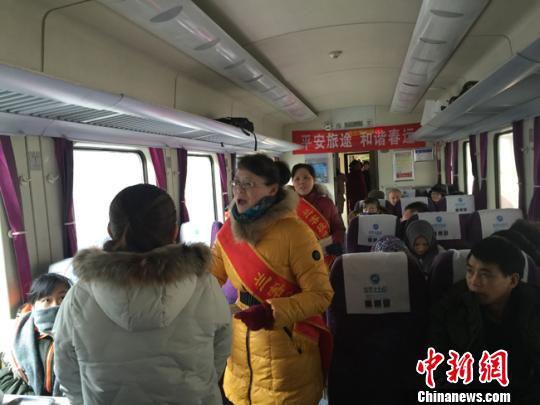 图为志愿者为旅客发放新年画册。 杨娜 摄
