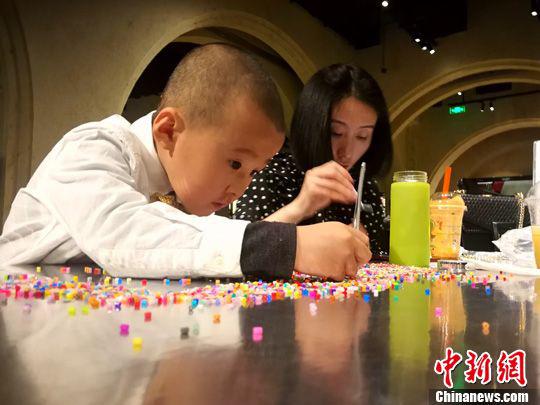 一对母子在书店内制作手工。中新社记者张添福摄