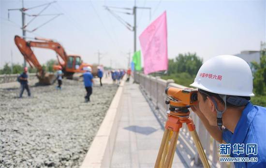 石济客专引入石家庄枢纽工程的建设人员在进行测量作业(6月15日摄)。
