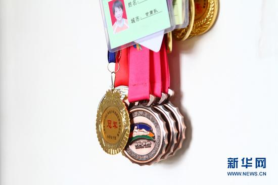 梦渊和姐姐获得的足球奖牌。新华网发(丁凯 摄)