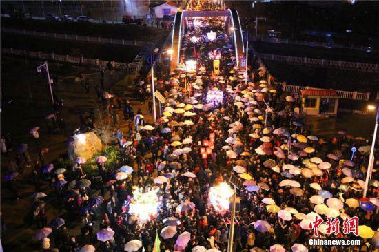 图为当天,天空下起小雨,数万民众撑起雨伞和“婆婆”的圣辇一起行进。 全当周 摄