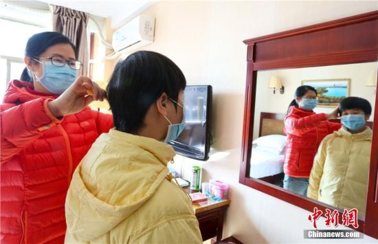 图为甘肃张掖首批湖北籍游客“解禁”第一天,母亲为女儿梳头。