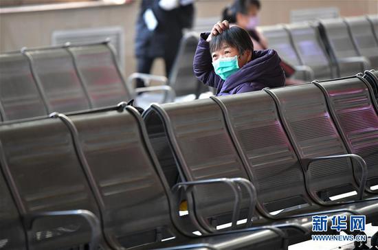2月10日,出行旅客在兰州火车站候车大厅保持间距候车。