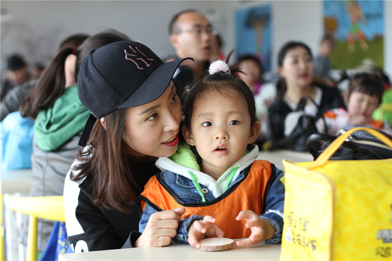 孩子和妈妈一起认真地听老师讲解