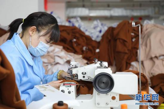 4月12日,毛艳琴正在扶贫车间内进行服装缝制工作。