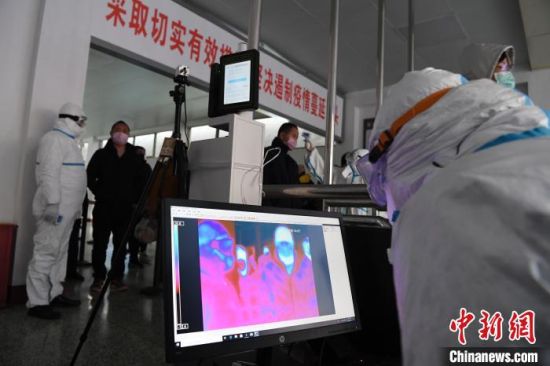 疫情发生后,兰州铁路局工作人员为旅客测量体温。