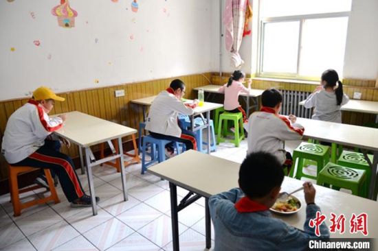 图为5月6日,兰州一家校外托护点的孩子们单人单桌吃午餐。