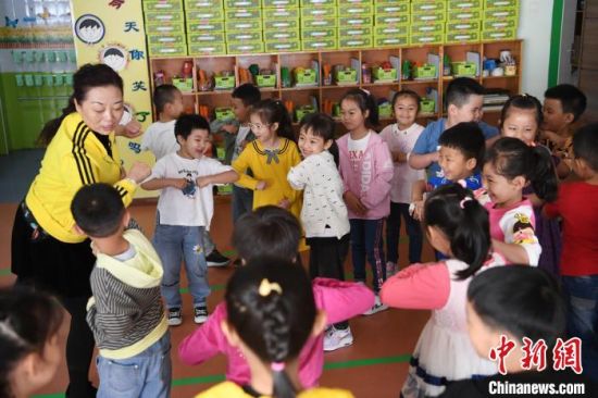 图为教师史春梅教授幼儿用“胳膊肘轻挨对方胳膊肘”的方式表示友好,用寓教于乐的方式将防疫知识贯穿其中。