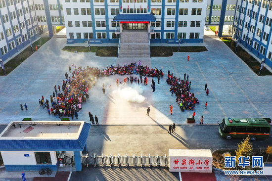 在甘肃省森林消防总队张掖市支队指战员指导下,甘泉街小学学生学习使用干粉灭火器。新华网发 (尤国功 摄)