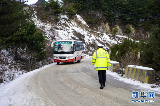 12月24日,民警在陇南市武都区积雪山路上巡逻。新华社记者 郎兵兵 摄