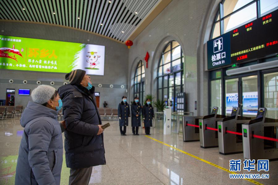 12月26日,在银西高铁甘肃环县站候车大厅,旅客查看银西高铁列车信息。新华社发(张永鑫 摄)