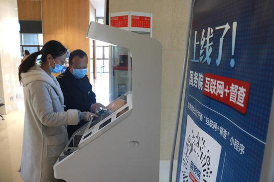 2020年12月22日,办事群众在敦煌市民中心通过自助办理一体机办理业务。