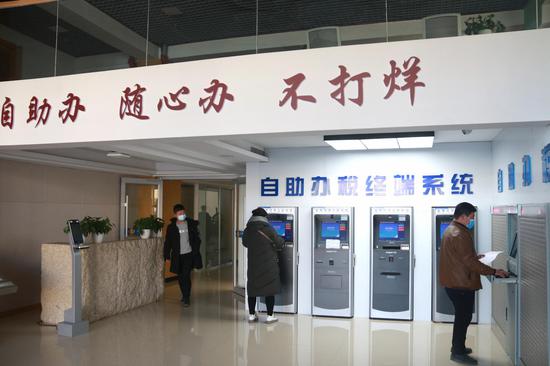 2020年12月22日,办事群众在敦煌市民中心自助服务区自助办理业务。