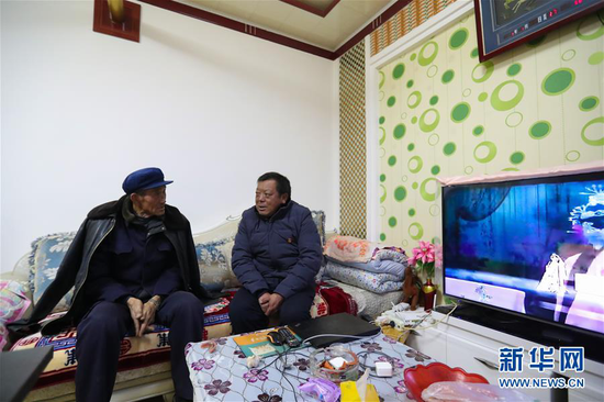 1月5日,在会宁县韩家集镇袁家坪村,任长太(右)在村民家走访。 新华社记者 马希平 摄