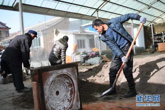 1月16日,几位匠人在甘肃省定西市岷县清水镇清水村鹏图铜铝铸造专业合作社里工作。新华社记者 陈斌 摄