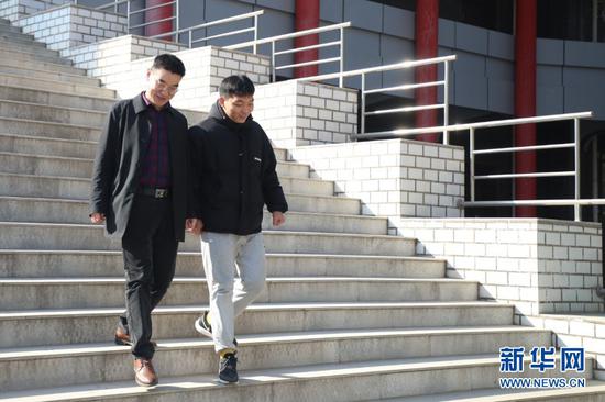 在甘肃农业大学,苌烁森(右)和班主任老师走出办公楼(1月22日摄)。新华社记者 马希平 摄