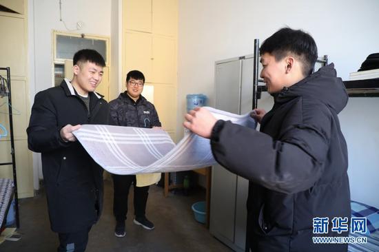 在甘肃农业大学学生宿舍,苌烁森(右一)和舍友整理寝具(1月22日摄)。新华社记者 马希平 摄