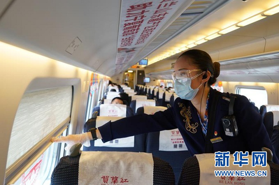 银西高铁线路列车上,一名列车员为旅客拉下窗帘。(中国铁路兰州局集团有限公司供图)