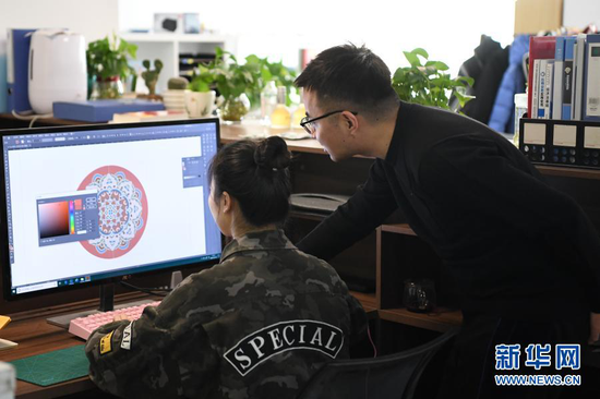 马成虎(右)和同事一起设计敦煌元素文创产品(1月14日摄)。新华社记者 陈斌 摄