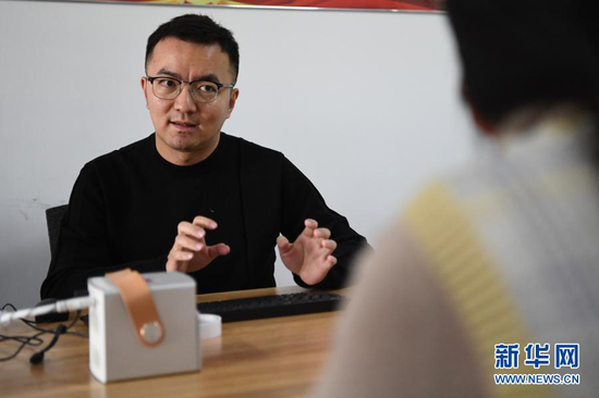 马成虎和同事交流敦煌壁画乐器复原(1月14日摄)。新华社记者 陈斌 摄