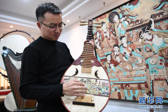 马成虎在介绍复原的敦煌壁画乐器(1月14日摄)。新华社记者 陈斌 摄