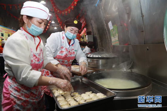 2月11日,在金川集团三矿区采矿二工区井下食堂,后勤服务人员为工人下饺子。新华社记者 杜哲宇 摄