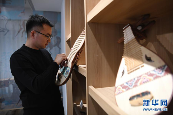 马成虎在整理复原的敦煌壁画乐器(1月14日摄)。新华社记者 陈斌 摄