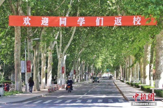 资料图:2020年5月,某高校校园内悬挂“欢迎同学们返校”的横幅。 赵晓 摄