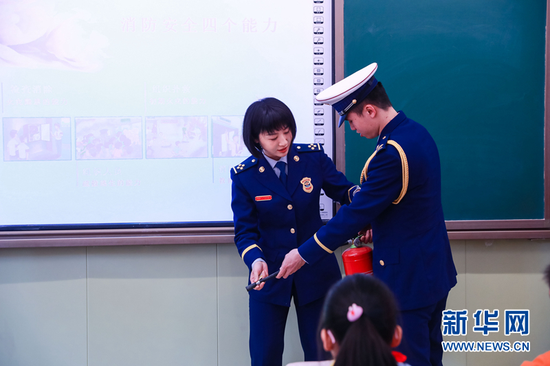 图为消防员演示如何正确使用灭火器扑救初起火灾。新华网发(张家纶 摄)