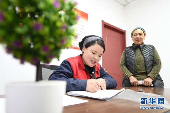 在东乡族自治县大树乡南阳洼村扶贫车间,马林红(左)统计车间工人当日集装袋生产数量(3月4日摄)。新华社记者 范培珅 摄
