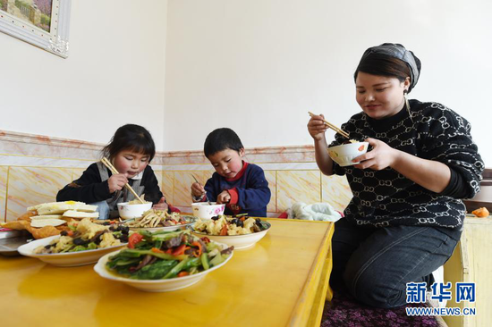 在东乡族自治县大树乡南阳洼村家中,马林红和孩子一起吃午饭(3月4日摄)。新华社记者 范培珅 摄