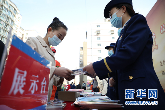 图为消防人员给市民发放宣传册。新华网发(刘欣瑜 摄)