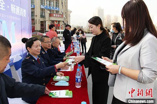 3月15日,兰州高新区举办纪念“3·15国际消费者权益日”活动,工作人员为民众发放消费提示手册。 高康迪 摄