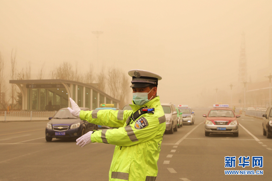 这是3月16日拍摄的交警正在甘肃省兰州市东方红广场十字路口执勤。新华网发(童张伟 摄)