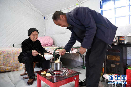 3月16日,在舟曲县果耶镇磨里村、果耶村滑坡灾害应急避险临时安置点,受灾群众在帐篷内吃饭。新华社记者 范培珅 摄