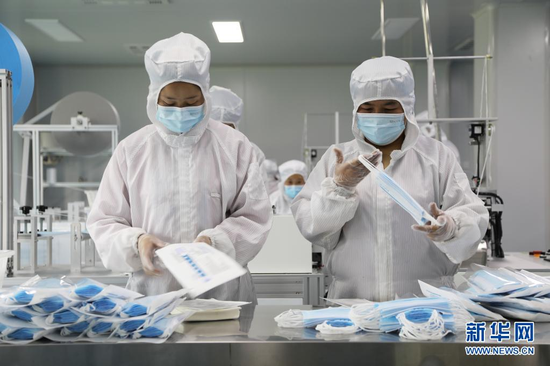 3月26日,在甘肃省临夏市南龙镇马家庄村的甘肃阳光智家网络科技有限公司医用口罩生产车间内,工作人员在加工生产医用口罩。新华社记者 马莎 摄