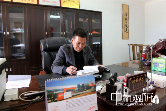 图为路涛利用闲余时间学习生猪养殖知识。