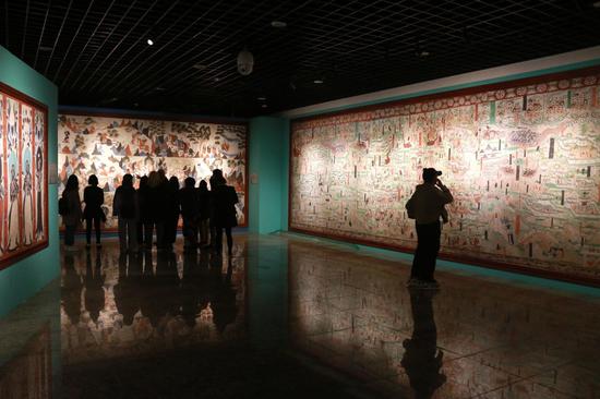 2021年4月9日,游客在甘肃敦煌国际会展中心参观“丝路美地”数字敦煌展。