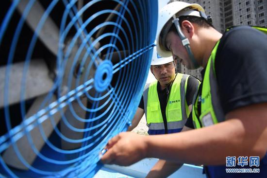 在甘肃省兰州市中建三局一处建设工地上,技术人员调试使用循环再生水的雾炮机(5月12日摄)。新华社记者 陈斌 摄