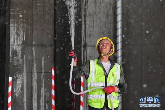 在甘肃省兰州市中建三局一处建设工地上,一名工人使用循环再生水施工作业(5月12日摄)。新华社记者 陈斌 摄